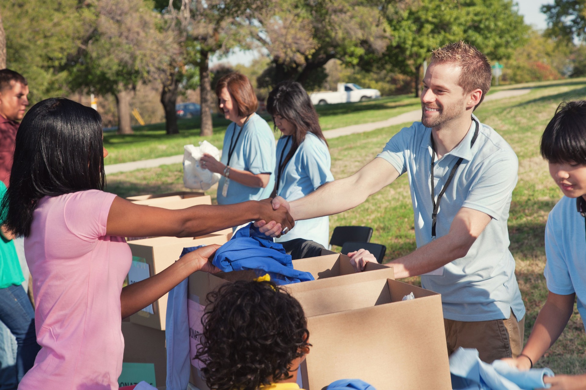 Male volunteer greets woman during clothing drive Male volunteer greets woman during clothing drive